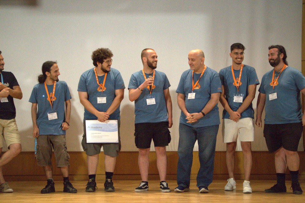 The local team receives the award for their hard work making Akademy possible.